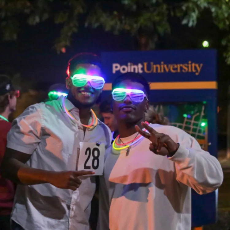 Two men with glow in the dark glasses holding up peace signs