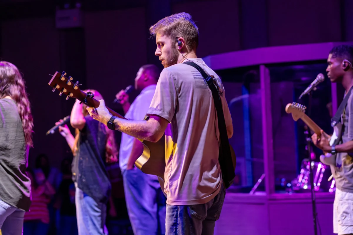 Student playing guitar at chapel